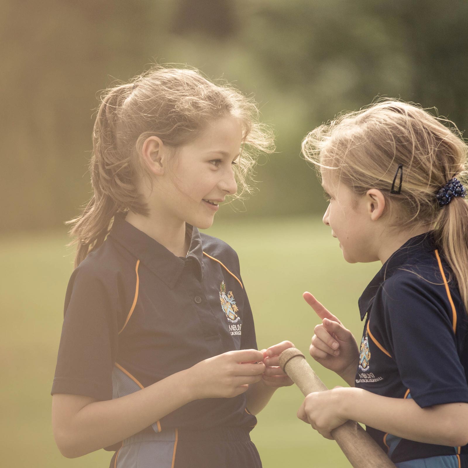 Two schoolgirls discussing sport tactics