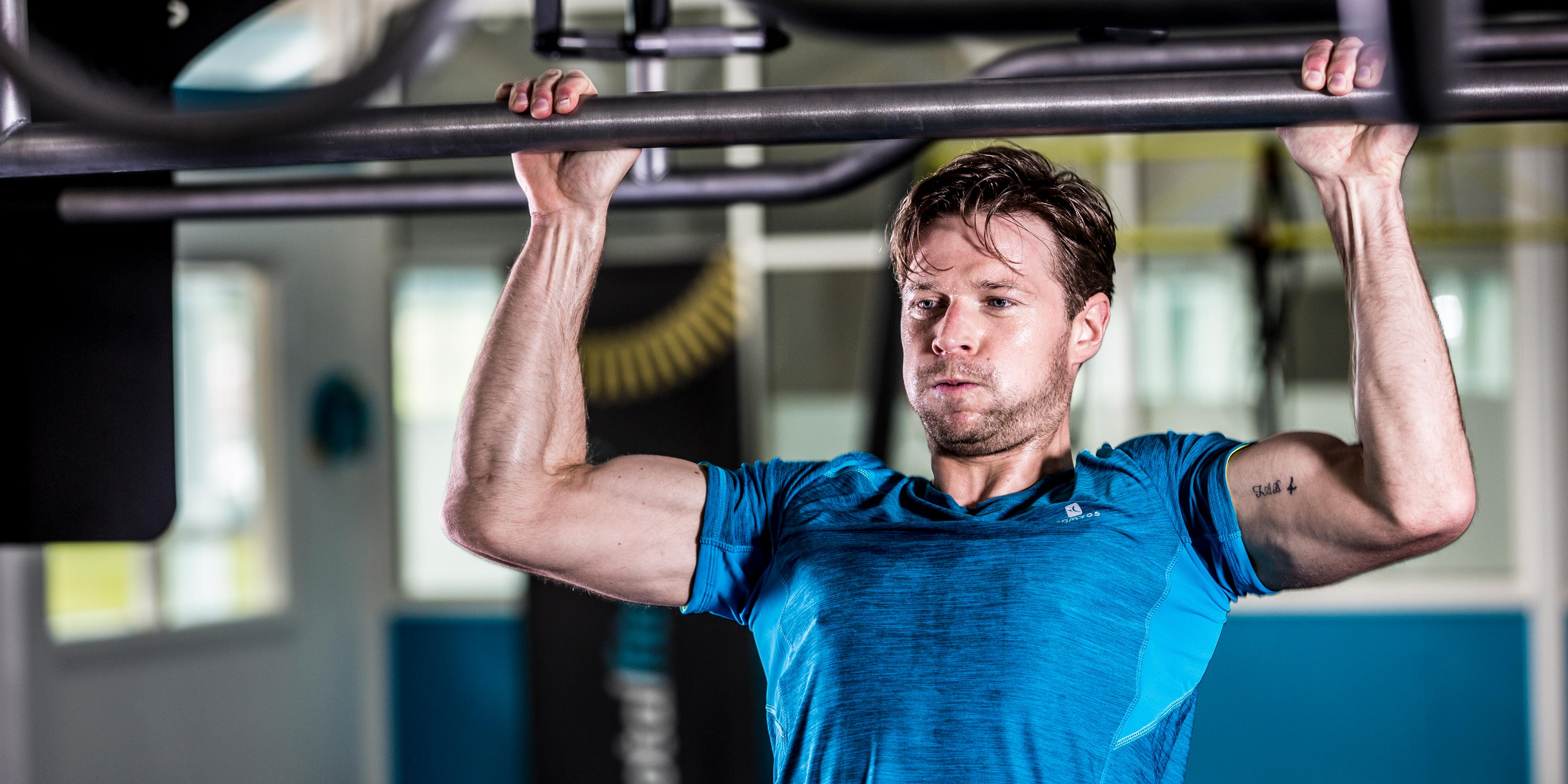 Male gym member doing chin-ups