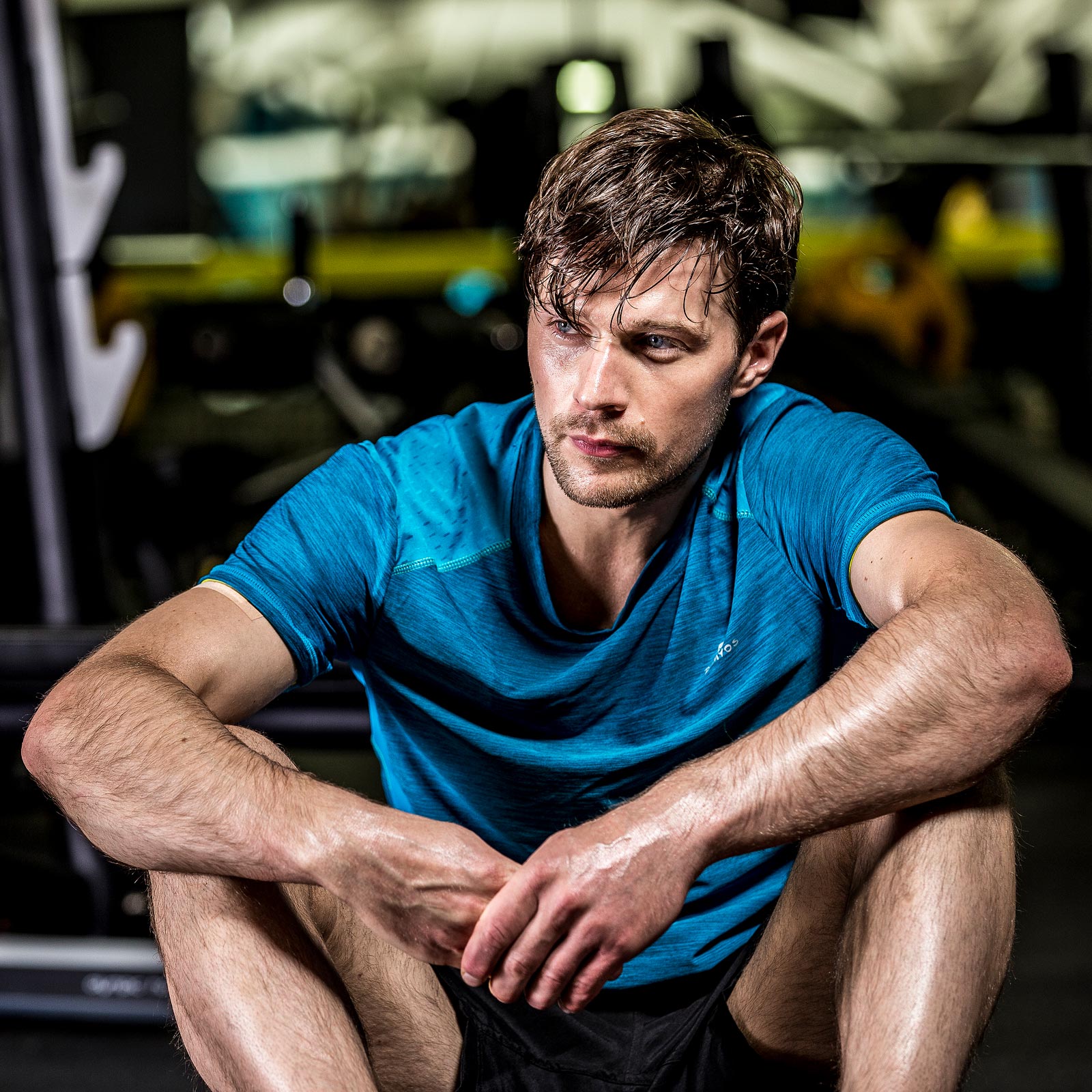 Male gym member relaxing after weight training